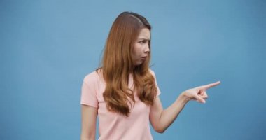 Genç Asya 'lı bayan gündelik pembe kötü ruh hali giyer, suratında belirsizlik olan eller kusar, mutsuz olur, mavi arka planda izole olur, bundan hoşlanmadım, insan duyguları yaşam tarzı, uzay konseptini kopyala..