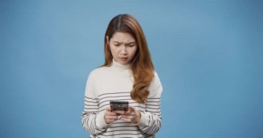 Genç Asyalı bayan üzgün bir şekilde süveter giyiyor. Akıllı telefon kullan. Sola, sağa bak. Negatif işaretler baş parmakları aşağıda, reddedilme kavramından hoşlanmadığını gösteriyor..