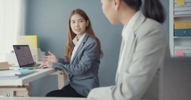 Bir grup Asyalı yaratıcı grup, çalışma masasında çalışırken ve iş yerindeki ofis masasında iletişim kurarken evrak ve dizüstü bilgisayardaki noktaları karşılaştırmak için projeyi tartışıyor. Ortak işbirliği, iş arkadaşı takım çalışması.