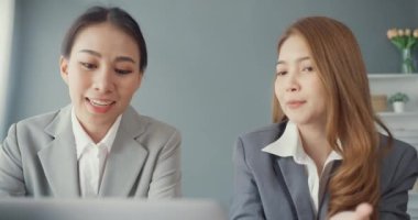 Bir grup Asyalı yaratıcı grup, çalışma masasında çalışırken ve iş yerindeki ofis masasında iletişim kurarken evrak ve dizüstü bilgisayardaki noktaları karşılaştırmak için projeyi tartışıyor. Ortak işbirliği, iş arkadaşı takım çalışması.
