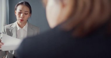 Genç Asyalı iş adamları ve iş kadınları, ortağıyla birlikte çalışarak küçük modern ev ofisinde takım çalışmasının tadını çıkarıyorlar..