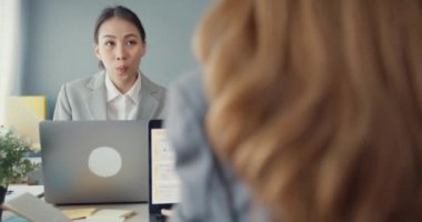 Bir grup Asyalı yaratıcı grup, çalışma masasında çalışırken ve iş yerindeki ofis masasında iletişim kurarken evrak ve dizüstü bilgisayardaki noktaları karşılaştırmak için projeyi tartışıyor. Ortak işbirliği, iş arkadaşı takım çalışması.