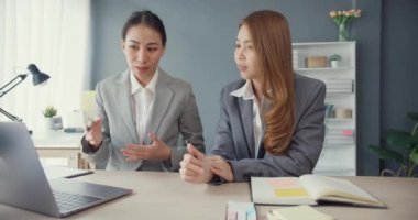 Bir grup Asyalı yaratıcı grup, çalışma masasında çalışırken ve iş yerindeki ofis masasında iletişim kurarken evrak ve dizüstü bilgisayardaki noktaları karşılaştırmak için projeyi tartışıyor. Ortak işbirliği, iş arkadaşı takım çalışması.