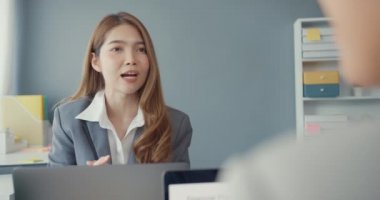 Bir grup Asyalı yaratıcı grup, çalışma masasında çalışırken ve iş yerindeki ofis masasında iletişim kurarken evrak ve dizüstü bilgisayardaki noktaları karşılaştırmak için projeyi tartışıyor. Ortak işbirliği, iş arkadaşı takım çalışması.
