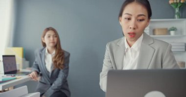 Bir grup Asyalı yaratıcı grup, çalışma masasında çalışırken ve iş yerindeki ofis masasında iletişim kurarken evrak ve dizüstü bilgisayardaki noktaları karşılaştırmak için projeyi tartışıyor. Ortak işbirliği, iş arkadaşı takım çalışması.