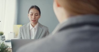 Bir grup Asyalı yaratıcı grup, çalışma masasında çalışırken ve iş yerindeki ofis masasında iletişim kurarken evrak ve dizüstü bilgisayardaki noktaları karşılaştırmak için projeyi tartışıyor. Ortak işbirliği, iş arkadaşı takım çalışması.