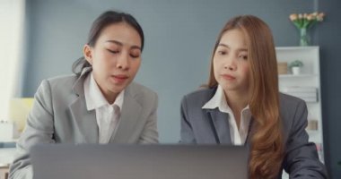 Bir grup Asyalı yaratıcı grup, çalışma masasında çalışırken ve iş yerindeki ofis masasında iletişim kurarken evrak ve dizüstü bilgisayardaki noktaları karşılaştırmak için projeyi tartışıyor. Ortak işbirliği, iş arkadaşı takım çalışması.