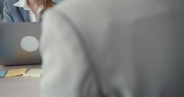 Genç Asyalı iş kadınlarının masadaki dizüstü bilgisayarlarını kullanarak iş yerindeki ofis masasında oturarak iletişim kurmalarını sağlıyoruz. Uzak webinar, sosyal uzaklık ve Coronavirüs 'ten sonra çalışma.