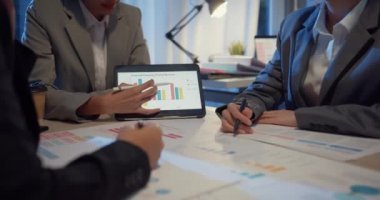 Yakın plan Asyalı iş adamları plan analiz istatistikleri beyin fırtınası ve Tablet Noktası Grafik Çizelgesi ekibinin başı ile merkez ofis gecesinde not alıyorlar. Finans stratejisi başarı kavramı.