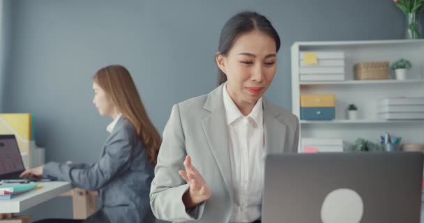 亚洲女商人在新的正常情况下与社会保持距离 以预防病毒 同时使用笔记本电脑向同事介绍在办公室工作时的视频通话计划 电晕病毒后的生命 — 图库视频影像
