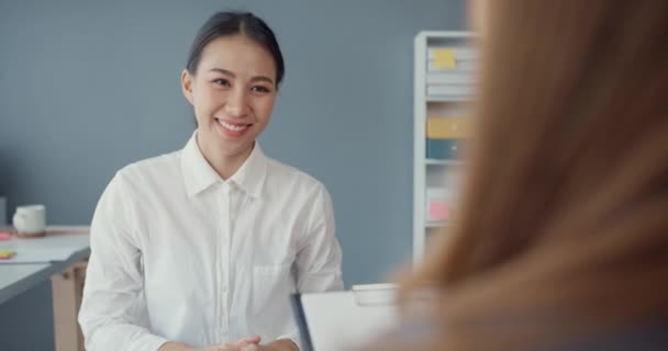 若いアジアのビジネスマン女性の応募者は 企業のポジションや職場のオフィスデスクに座っている企業のビジネスミーティング中に就職面接を通過します 面接のコンセプトで候補者を雇う — ストック動画