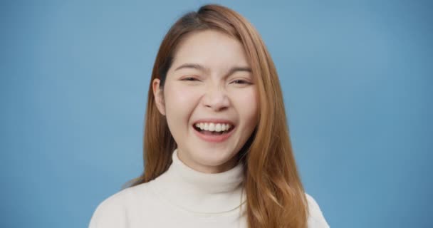 年轻迷人而快乐的亚洲女士笑着看着相机 满面春风 眨眼间 流露出良好的情绪 在蓝色的背景下孤立无援 幸福生活图片 复制空间概念 — 图库视频影像