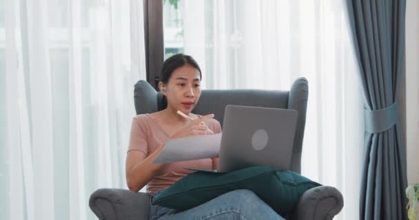 아시아 사업가들은 집에서 거실에서 일하는 노트북을 사용하여 동료들에게 비디오 계획에 — 비디오