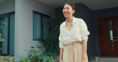 Young Asian delivery man with bicycle in red uniform carry case box knock door home online shopping paper bag to woman in front of door lady scan QR code payment on smartphone at house concept.