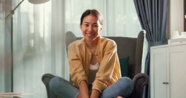 Youth asia female girl or university student sit on sofa chair Relaxed serene take a rest, happy calm lady dream enjoy wellbeing breathing fresh air  in living room at house. Home lifestyle concept.