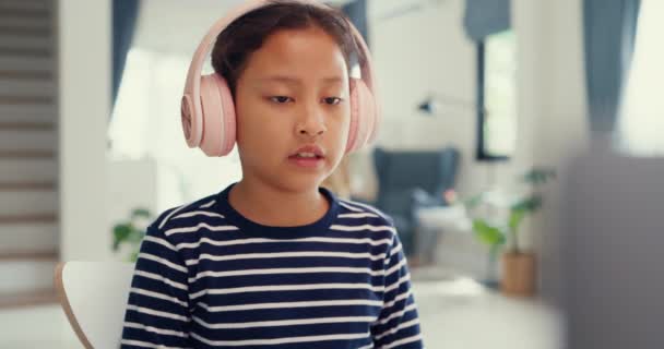 Ασιατική Κοριτσάκι Πουλόβερ Φορούν Ακουστικά Κάθονται Μπροστά Από Γραφείο Σημειωματάριο — Αρχείο Βίντεο