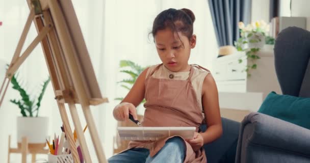 Азійська Дівчинка Фартухом Сидить Дивані Перед Полотном Малюючи Акриловий Колір — стокове відео