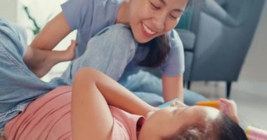 Close-up Asian toddler little girl daughter with mother and playing on carpet on the floor having fun and joyful in living room at home. Family spend time together, Creative lifestyle for kid concept.