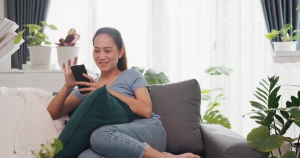 Mladá Asijská Žena Nosit Příležitostné Stránky Gauči Používat Smartphone Pocit — Stock video