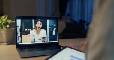 Genç Asyalı iş kadını resmi giyiniyor. Tablet tutucu Stylus 'la birlikte masanın önünde oturuyor. Ev gecesinde iş arkadaşıyla birlikte samimi oturma odasında laptoplu ekran video toplantısına odaklanıyor. Fazla mesai konsepti.