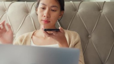 Yatakta dizüstü bilgisayarı olan Asyalı bir kız akıllı telefon kullanır, akıllı telefonda sanal asistana sesli komutlar verir, sabahları evdeki rahat yatak odasında sesli mesaj kaydı için konuşur..