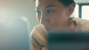 Mutlu, gülümseyen, beyaz krem pijamalı bir Asyalı kız üniversitesi. Kabarık, rahat bir yatağa uzan. Kredi kartı kullan..