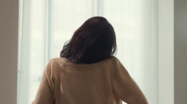 Yakından bakınca beyaz krem pijamalı Asyalı kız uykulu tembel ve kabarık kollarını yatak odasındaki yumuşak yatağa dayamış olarak uyanıyor. Kadın sabah titreşimleri konsepti.
