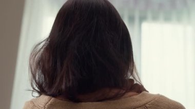 Yakından bakınca beyaz krem pijamalı Asyalı kız uykulu tembel ve kabarık kollarını yatak odasındaki yumuşak yatağa dayamış olarak uyanıyor. Kadın sabah titreşimleri konsepti.