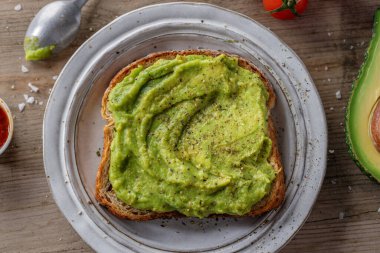 Tasty appetizing sandwich bread with mashed avocado served on plate. 