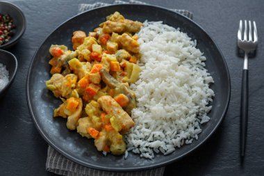 Tasty cooked autumn chicken chunks with vegetables and rice served on plate. Top View