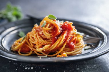 Pasta spaghetti with tomato sauce and cheese served on plate. 