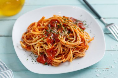 Appetizing pasta with tomato sauce and parmesan on plate. Closeup