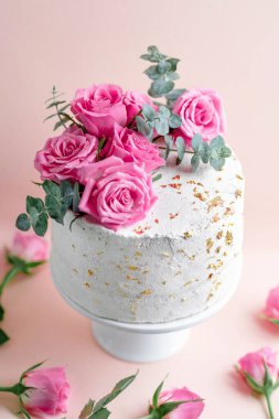 Wedding cake with roses and deco on plate. Closeup 