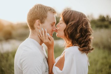 Young couple kissing and huging outdoors in summer. Selective focus. 