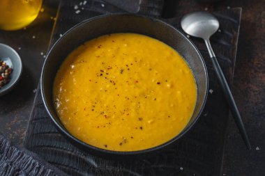 Tasty appetizing oriental pumpkin lentil soup with ginger served in bowl. Closeup