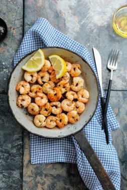Tasty appetizing fried shrimps on pan on dark stone background. Top View. 
