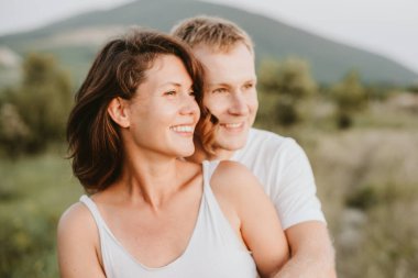 Happy young couple on nature background. Girl looking aside. Love concept