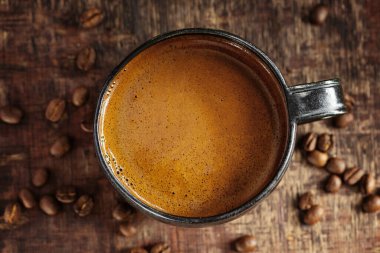 Coffee espresso with coffee beans on old wooden background. Closeup