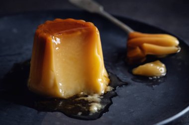 Spanish dessert flan with sauce served on plate. Closeup 