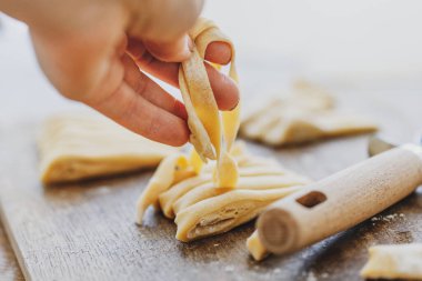 Rolling Fresh homemade pasta with flour on wooden board on table. 