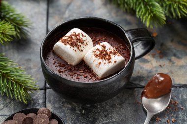 Hot chocolate served in cup with murshmallows on wooden background. 