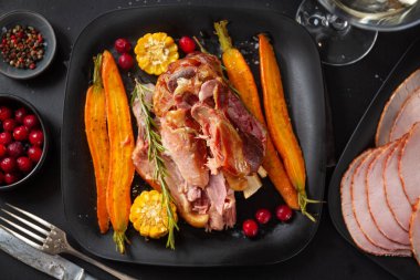 Baked christmas pork with vegetables and spices on plate. Closeup 