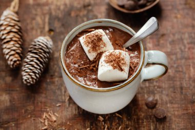 Hot chocolate served in cup with murshmallows on wooden background. 