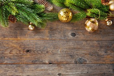 Christmas background with baubles, fir and present on old wooden table. 