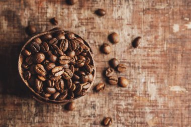 Coffee beans on wooden small bowls on old wooden vintage background. Closeup