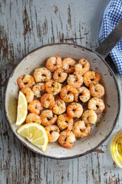Tasty appetizing fried shrimps on pan on dark stone background. Top View. 