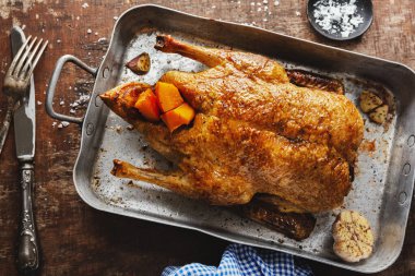Baked roasted duck with vegetables on pan on old wooden background. Top View. 