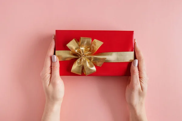 Woman Holding Giftbox Golden Ribbon Hands Pink Background —  Fotos de Stock