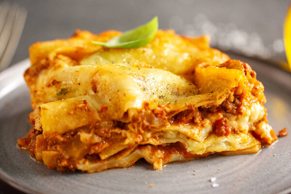 Tasty baked prepared classic italian lasagne in casserole on bright background. Closeup