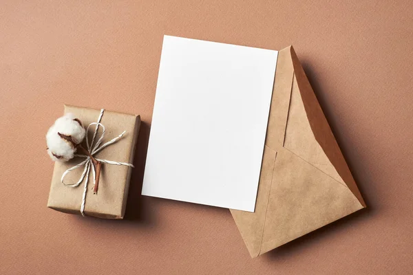 Zaproszenie lub kartka okolicznościowa makieta z pudełkiem prezentów, kopertą i naturalnymi kwiatami bawełny — Zdjęcie stockowe